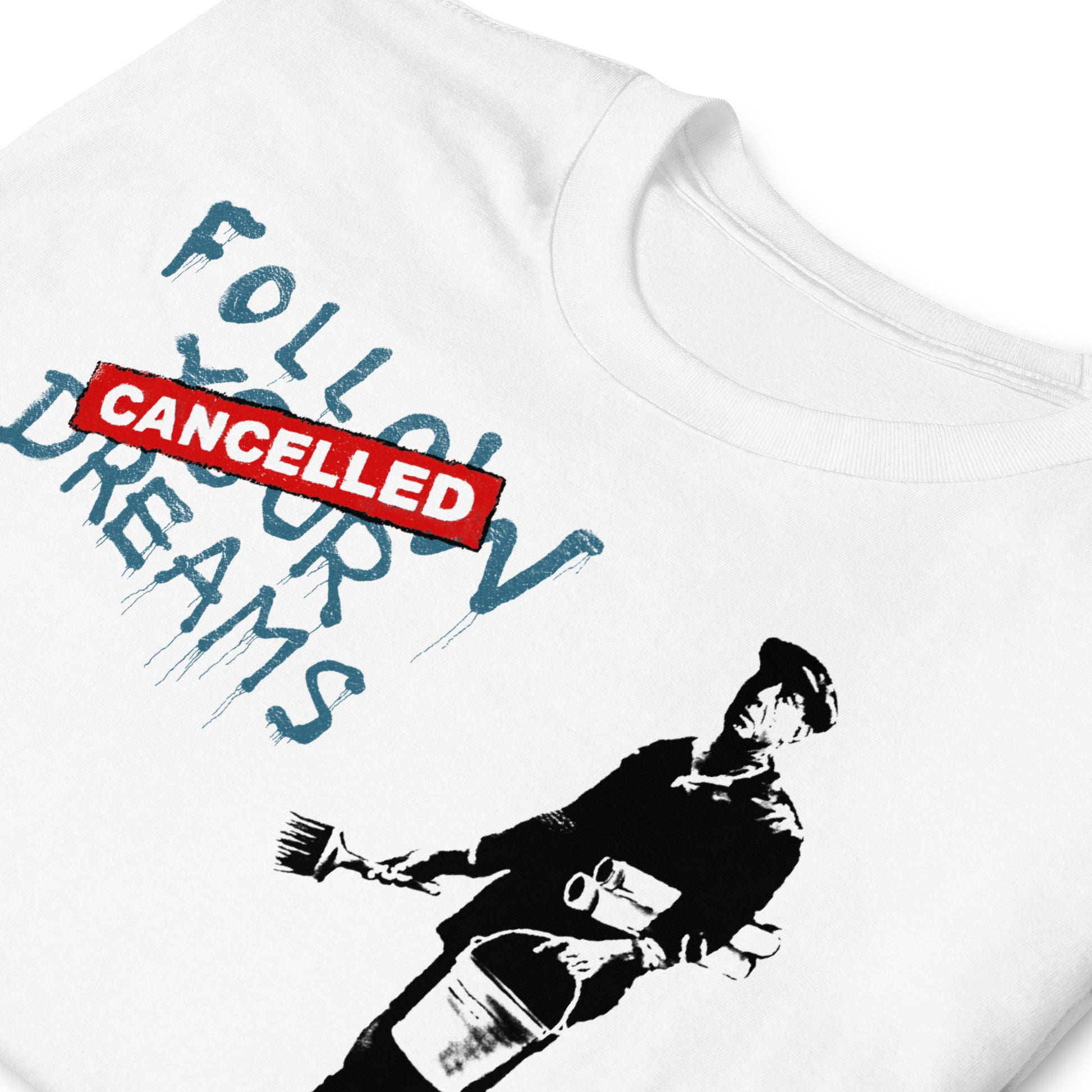 detalle de camiseta follow your dreams cancelled banksy blanca