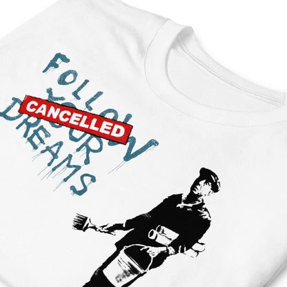 detalle de camiseta follow your dreams cancelled banksy blanca