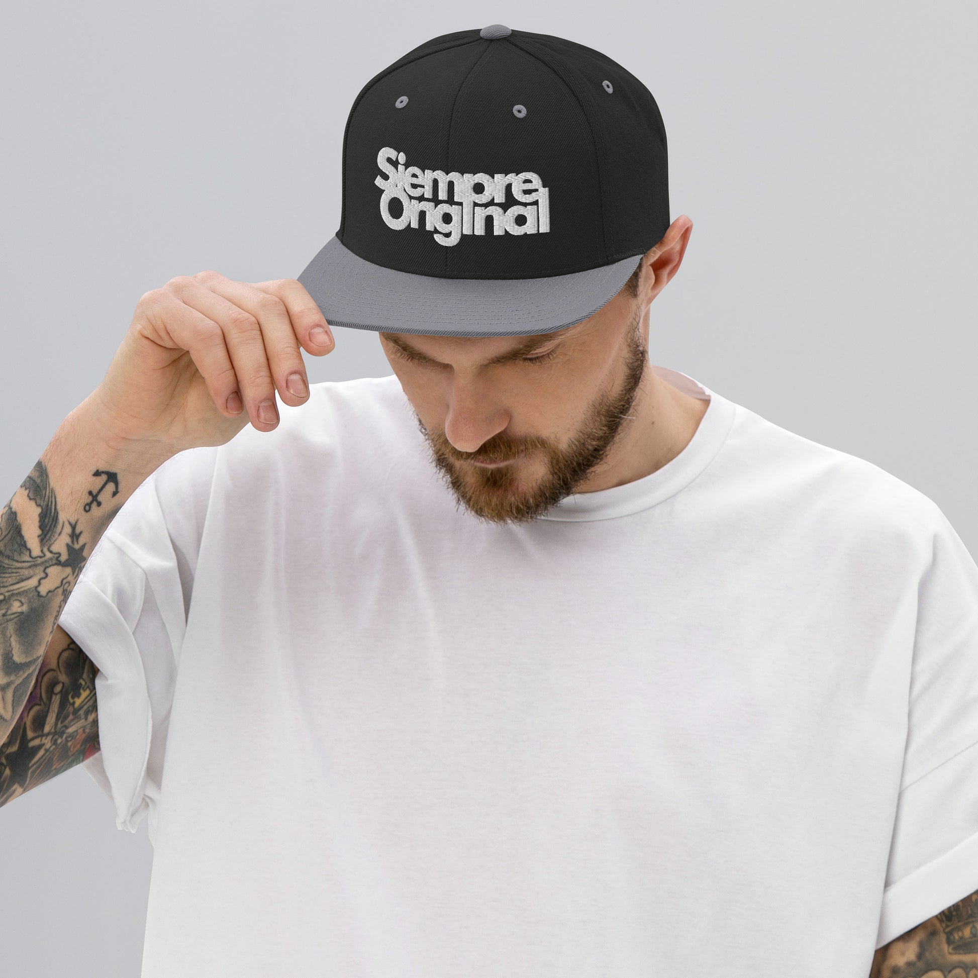 hombre con gorra snapback con logo siempre original negra y gris